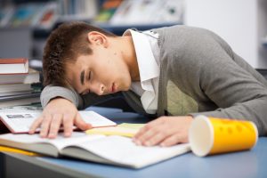 Tired student sleeping at the desk