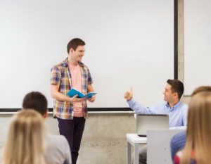 group of smiling students and teacher in classroom